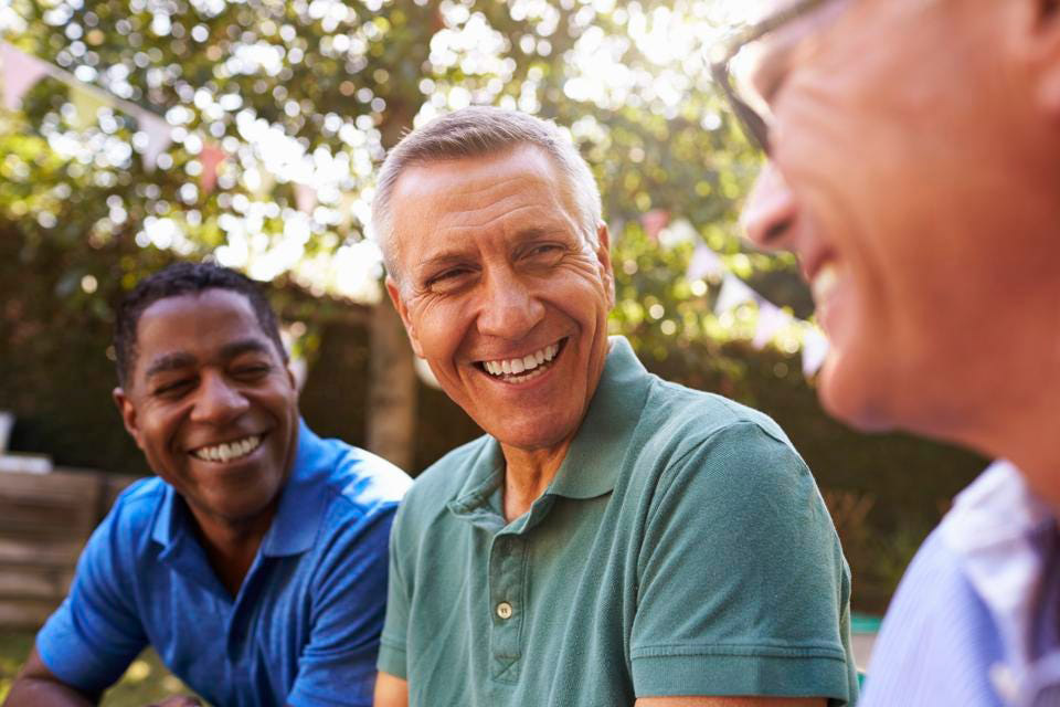 Friends laugh and smile as they relax together. Via Getty Images. GETTY